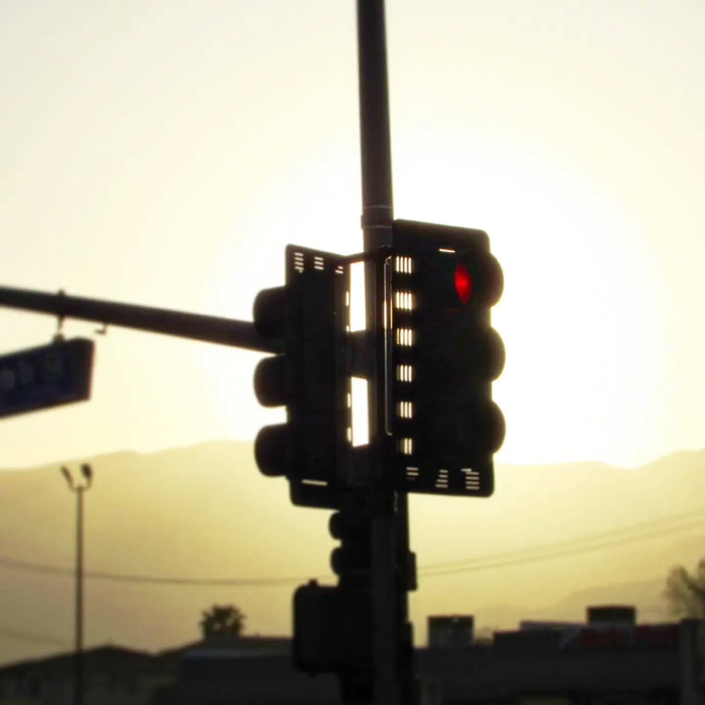 Silhouetted traffic signal against a hazy amber sunset
