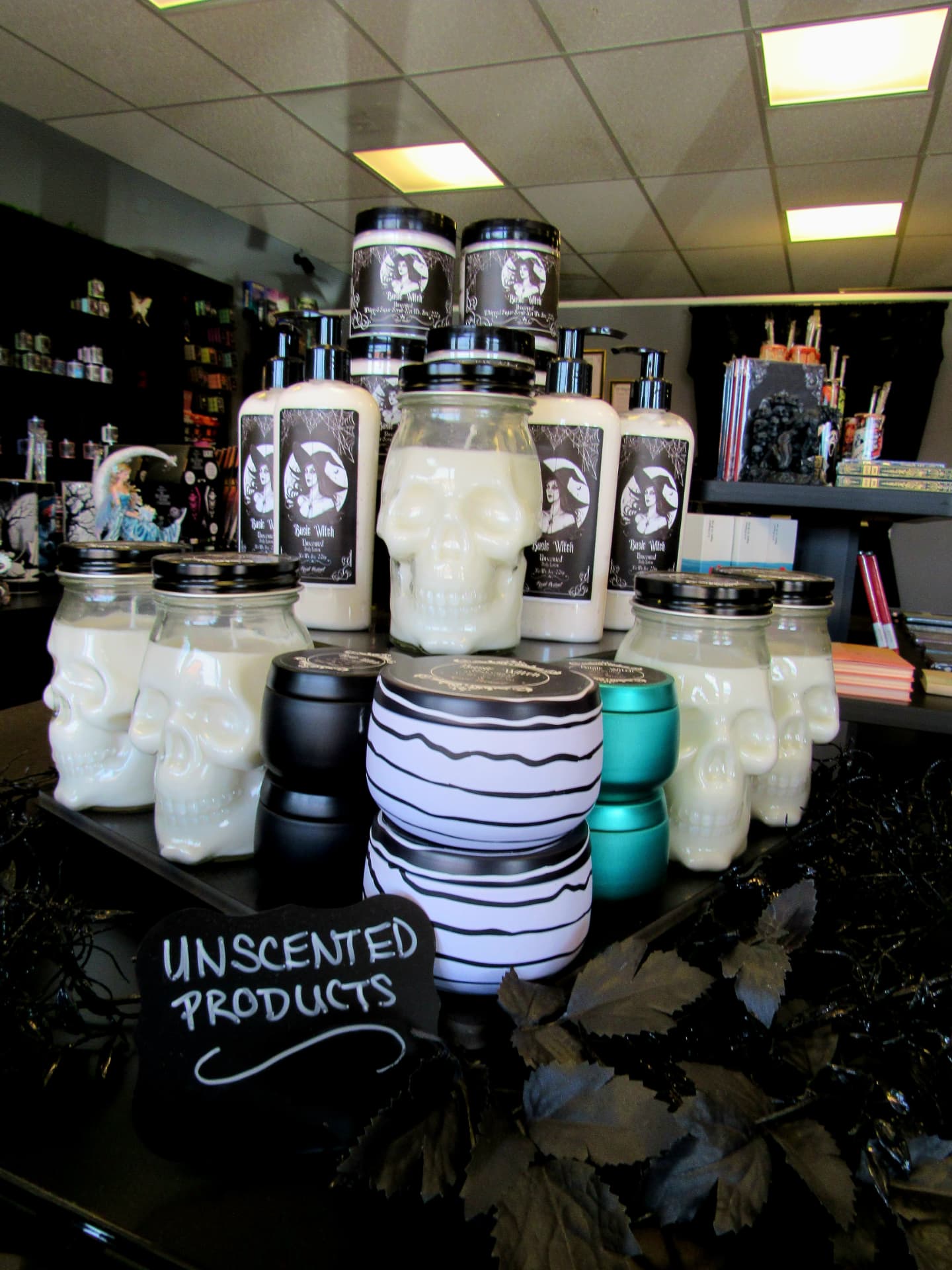 Skull-shaped soy candles and labelled body lotions arranged on a retail display table