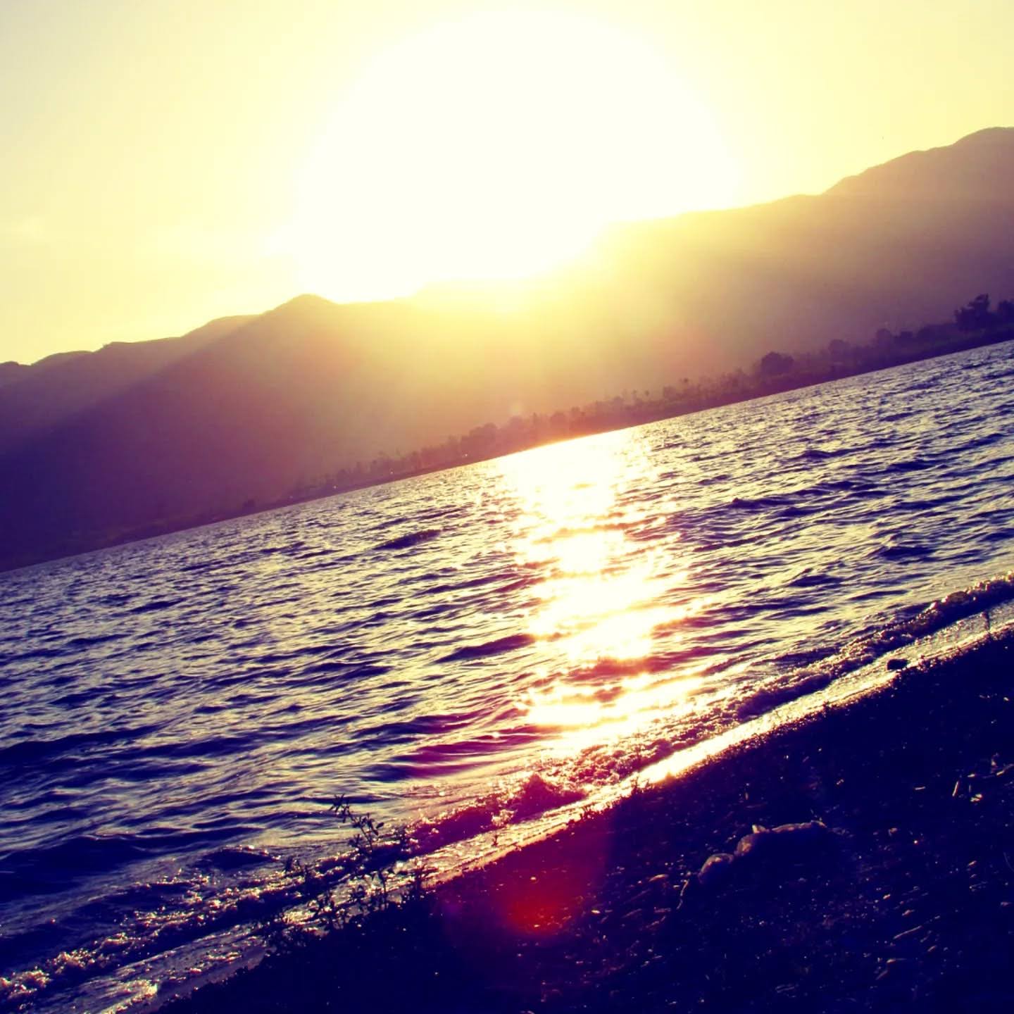 Low sun spilling gold across rippled lake water